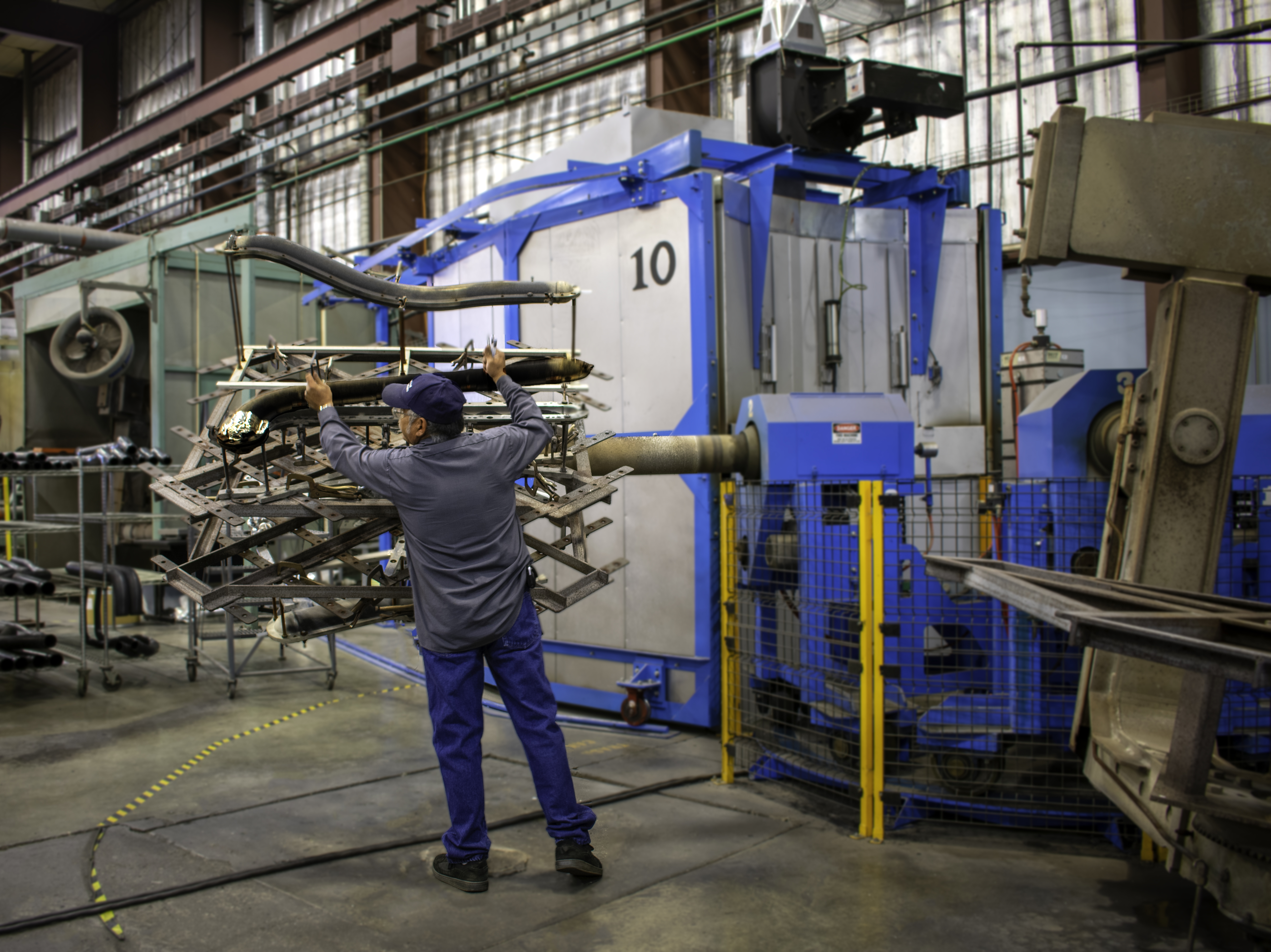 A worker attaching a mold for manufacturing thermoplastic interior components